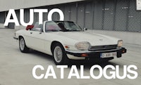 a white car parked in front of a building with the words auto catalogs