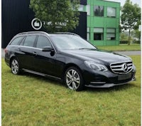 the black mercedes e - class estate parked in front of a building