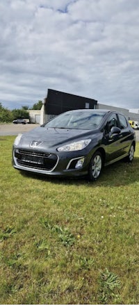 a black car parked in a grassy field