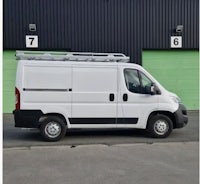 a white van parked in front of a garage