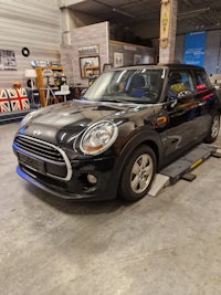 a black mini cooper parked in a garage